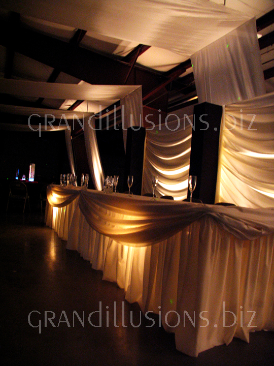 lighted head table and swag backdrop wedding decorating